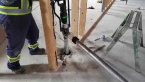 Close up of a ground screw driver drilling on concrete